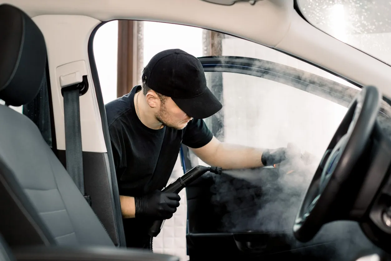 Detailer steam cleaning a car interior at The Oasis Eco