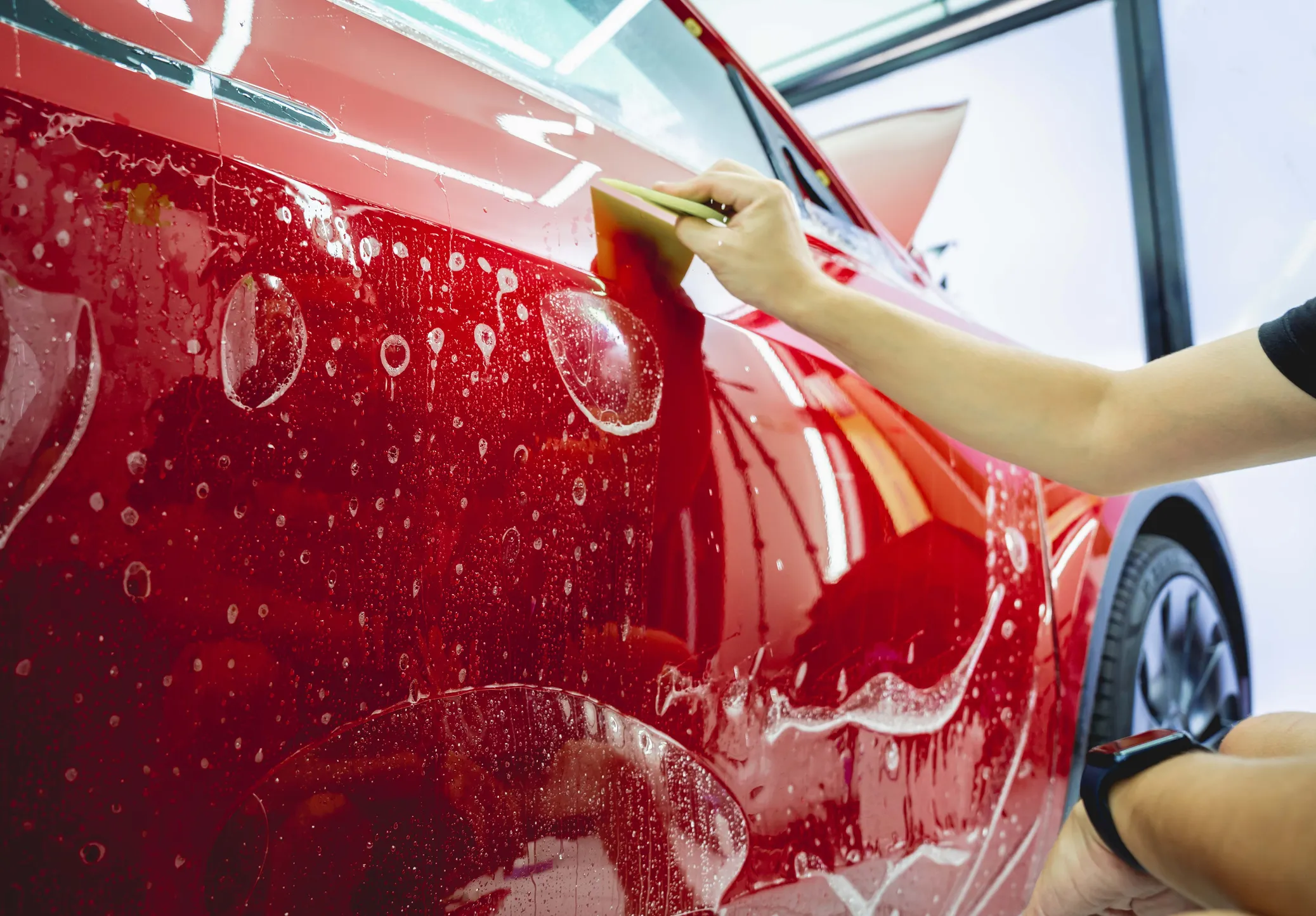 Installing paint protection film on a red car
