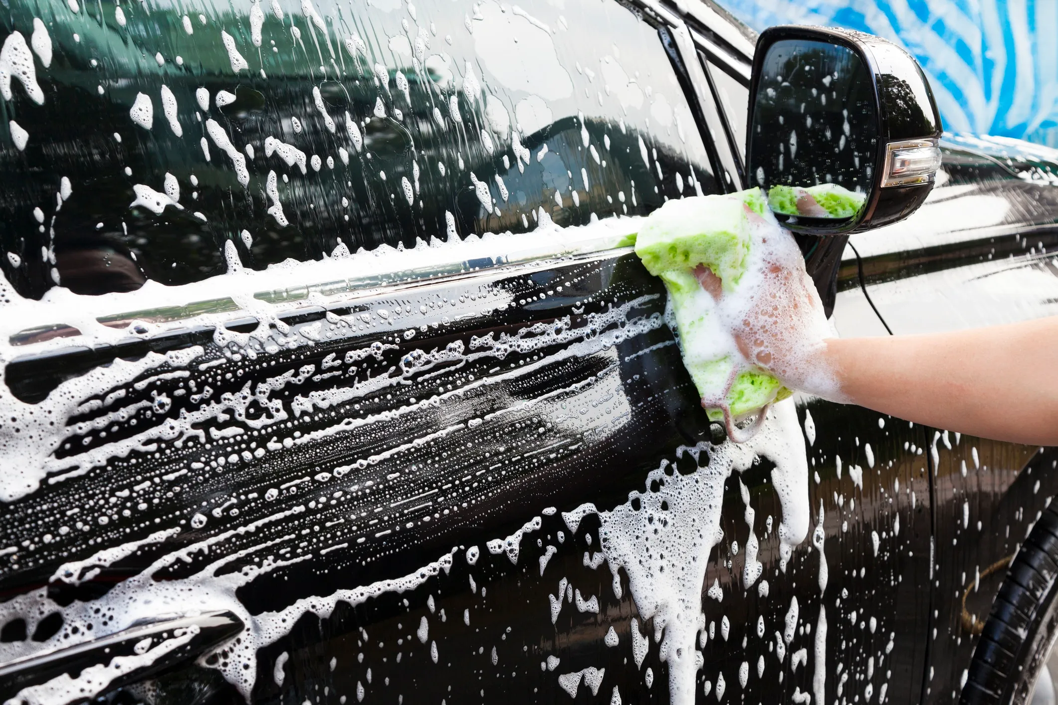 Hand washing a car with foam